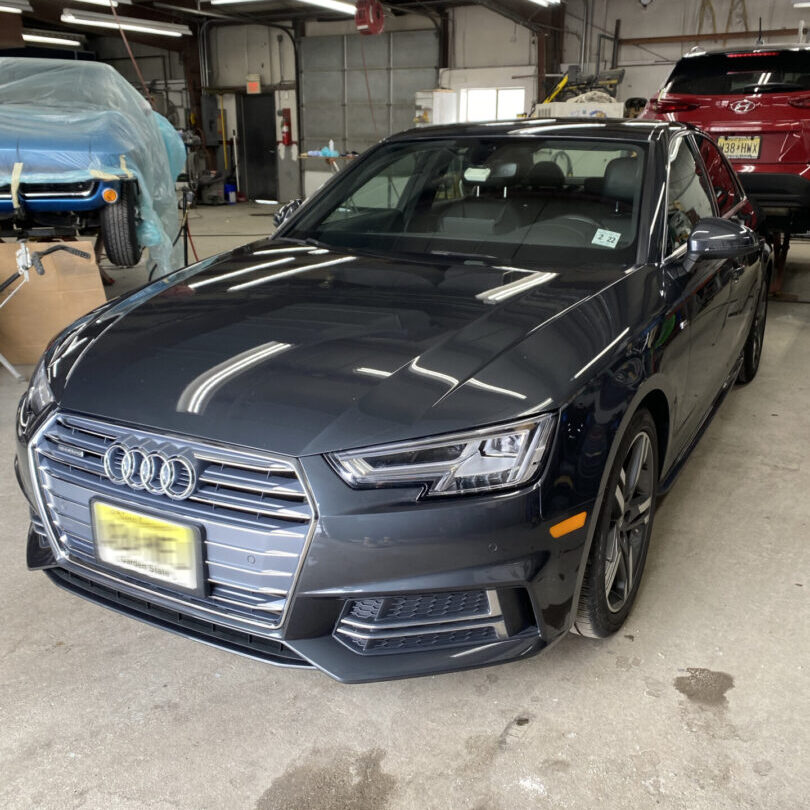 A car parked in the garage with its hood up.